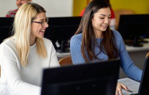 two students with a laptop